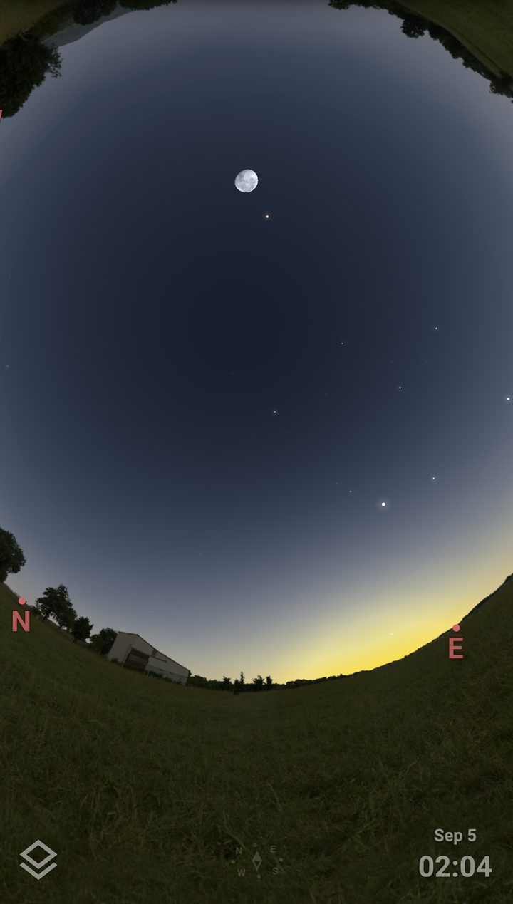 A dawn sky with the Moon and the planets over a farm, seen through the app